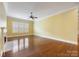 Bright living room featuring hardwood floors, fireplace, and large windows at 16919 Hedgerow Park Rd, Charlotte, NC 28277