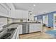 Bright, open kitchen with white cabinets, stainless steel dishwasher, and hardwood floors at 2006 Holly Villa Cir, Indian Trail, NC 28079