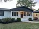Inviting front porch with classic columns, decorative shrubs, and a secure front door at 201 Harley St, Wadesboro, NC 28170