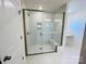 Modern walk-in shower with glass doors, white tile, built-in bench, and sleek fixtures at 2019 Puddle Pond Rd, Indian Trail, NC 28079