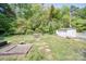 Spacious backyard with open lawn area, garden beds, and utility shed in a lush, green setting at 20337 Nc Hwy 73 Hwy, Albemarle, NC 28001