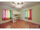 Bright bedroom featuring a modern bunk bed with desk, colorful curtains, and wood floors at 20337 Nc Hwy 73 Hwy, Albemarle, NC 28001