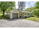 Exterior shot of the home featuring a detached garage, bright siding, and a cracked concrete driveway at 20337 Nc Hwy 73 Hwy, Albemarle, NC 28001