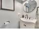 Stylish half-bathroom with a pedestal sink, dark fixtures, and decorative wall art at 2062 High Pines Rd, Rock Hill, SC 29732