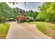 Scenic view of a beautiful home with a long driveway, lush landscaping, and mature trees at 2062 High Pines Rd, Rock Hill, SC 29732