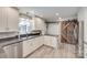 Updated kitchen with stainless appliances, white cabinetry, wood-look tile floor, and stylish sliding barn door at 2062 High Pines Rd, Rock Hill, SC 29732