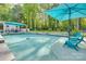Inviting backyard pool area with umbrella, mature trees, stone surround, and comfortable lounge chairs at 2062 High Pines Rd, Rock Hill, SC 29732