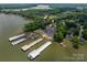 Scenic aerial view of a waterfront property near a marina with boat slips and parking at 216 Commodore Ct, Belmont, NC 28012