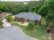Aerial view of a brick home, landscaped yard, and beautiful wooded surroundings at 216 Commodore Ct, Belmont, NC 28012