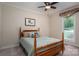 Bedroom features a wooden bed frame, ceiling fan, and window allowing natural light at 216 Commodore Ct, Belmont, NC 28012