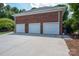 A spacious three-car garage with a brick exterior provides ample parking and storage space at 216 Commodore Ct, Belmont, NC 28012