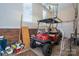 Spacious garage featuring a red golf cart with ceiling fan and ample storage at 216 Commodore Ct, Belmont, NC 28012