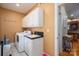 Bright laundry room features white cabinets, sink, washer, and dryer for convenience at 216 Commodore Ct, Belmont, NC 28012