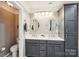 Bathroom with double vanity, modern lighting, and a tall storage cabinet at 2254 Donnington Nw Ln, Concord, NC 28027