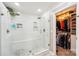 Luxurious bathroom features a walk-in shower, pebble tile floor, and a view of a walk-in closet at 2254 Donnington Nw Ln, Concord, NC 28027