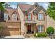 Charming brick two-story home with a well-manicured lawn, dormer windows, and a lovely red wreath on the front door at 2254 Donnington Nw Ln, Concord, NC 28027