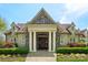 Stately home entrance with stone columns, a wooden door, and manicured landscaping at 2254 Donnington Nw Ln, Concord, NC 28027