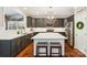 Modern kitchen with stainless steel appliances, an island with seating, and stylish gray cabinets with white marble countertops at 2254 Donnington Nw Ln, Concord, NC 28027