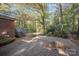 Backyard featuring a concrete patio, a stairway, mature trees, and surrounding greenery at 2643 Rolling Hills Dr, Monroe, NC 28110