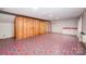 Spacious basement featuring colorful patterned flooring, exposed framing, a utility sink, and white shelving at 2643 Rolling Hills Dr, Monroe, NC 28110