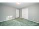 Bedroom with grey patterned wallpaper, double-door closet, and green carpet at 2643 Rolling Hills Dr, Monroe, NC 28110