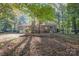 The home features a brick exterior, multilevel deck, and a backyard full of trees at 2643 Rolling Hills Dr, Monroe, NC 28110