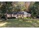 Charming red brick home with a well-manicured lawn and mature trees at 2643 Rolling Hills Dr, Monroe, NC 28110