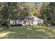 Charming red brick home with a well-manicured lawn and mature trees at 2643 Rolling Hills Dr, Monroe, NC 28110