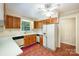Traditional kitchen with brick flooring, wood cabinets, and white appliances at 2643 Rolling Hills Dr, Monroe, NC 28110