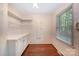Functional laundry room with ample storage space, shelving, a window, and floral wallpaper at 2643 Rolling Hills Dr, Monroe, NC 28110