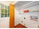 Bright laundry room featuring shelving, exterior access, and tile flooring at 2643 Rolling Hills Dr, Monroe, NC 28110