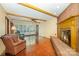 Inviting living room featuring hardwood floors, a brick fireplace, beamed ceilings, and a sunlit window at 2643 Rolling Hills Dr, Monroe, NC 28110