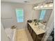 Bathroom featuring a soaking tub, dual sink vanity, and a large mirror at 2752 Sawbridge Ln, Gastonia, NC 28056