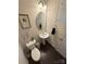 Elegant half bathroom features a pedestal sink, oval mirror, decorative accents, and a hardwood floor at 2752 Sawbridge Ln, Gastonia, NC 28056