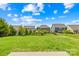 View of backyards with lush green grass, trees, and blue sky above homes in this community at 3022 Oakmere Rd, Waxhaw, NC 28173