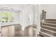 Bright foyer with hardwood floors, stairway, and a view into the adjacent sunlit room through glass doors at 3022 Oakmere Rd, Waxhaw, NC 28173
