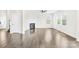 Open living room with hardwood floors, fireplace, windows, and adjacent staircase at 3022 Oakmere Rd, Waxhaw, NC 28173