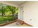 Covered porch with brick stairs leads into a green backyard surrounded by mature trees at 304 W Fourth St, Cherryville, NC 28021
