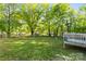 Lush backyard with a stone fire pit and mature trees, a perfect setting for relaxation at 304 W Fourth St, Cherryville, NC 28021
