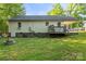 Rear exterior view of the house with a fire pit, grassy lawn, deck and outdoor utilities at 304 W Fourth St, Cherryville, NC 28021