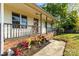 Cozy covered front porch with decorative elements, vibrant flowers, and manicured landscaping at 304 W Fourth St, Cherryville, NC 28021