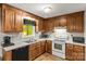 Functional kitchen featuring wood cabinets, white appliances, and a double-basin stainless steel sink at 304 W Fourth St, Cherryville, NC 28021