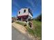 Charming two-story home with red awnings, a cozy porch swing, and well-maintained lawn at 310 4Th W St, Newton, NC 28658