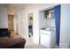 Interior laundry area showing a washing machine, shelving with storage, and access to adjoining rooms at 310 4Th W St, Newton, NC 28658
