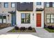 Close-up of the modern townhome's brick and siding exterior with a vibrant red door and manicured landscaping at 3223 Beans Blvd, Charlotte, NC 28203