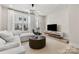 Bright living room with modern furnishings, including a plush sofa, sleek TV console, and contemporary lighting at 3223 Beans Blvd, Charlotte, NC 28203