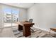 Bright office space featuring a wooden desk, modern rug, and a sliding glass door leading to a balcony at 3223 Beans Blvd, Charlotte, NC 28203