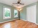 Inviting bedroom with two windows, a ceiling fan, and a closet, complemented by beautiful hardwood floors at 3612 Woodnotch Ct, Charlotte, NC 28269