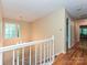 Welcoming hallway featuring hardwood floors, a staircase with white railings, and ample natural light at 3612 Woodnotch Ct, Charlotte, NC 28269