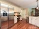 Kitchen featuring stainless steel refrigerator, white cabinetry, wood-style floors, and built in desk at 3612 Woodnotch Ct, Charlotte, NC 28269
